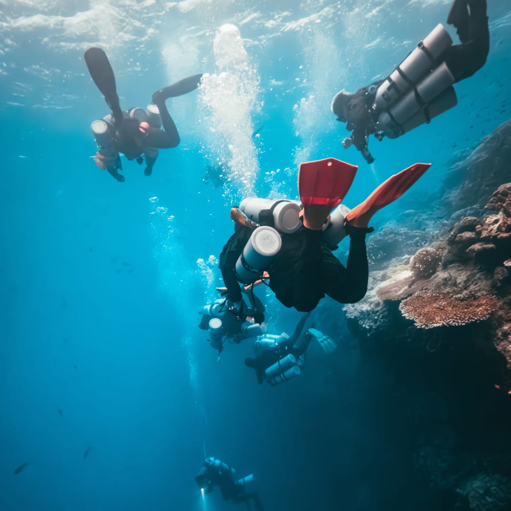 Koh tao divers extended range technical diving with multiple tanks over coral reef