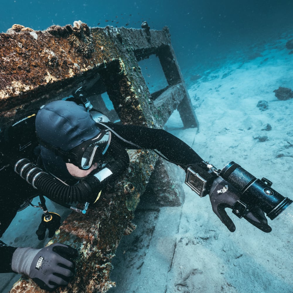 Koh tao divers CCR diver swimming through a coral-covered underwater structure