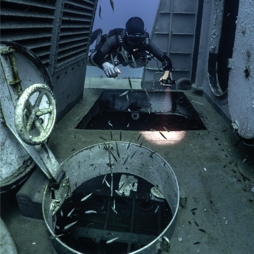 Koh Tao Divers sidemount diver inspecting compartments of a shipwreck underwater