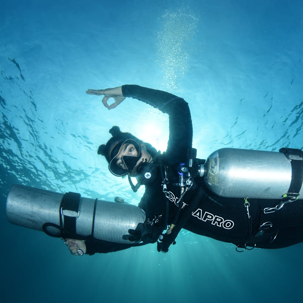 Koh tao divers diver underwater with twin sidemount tanks showing ok mark