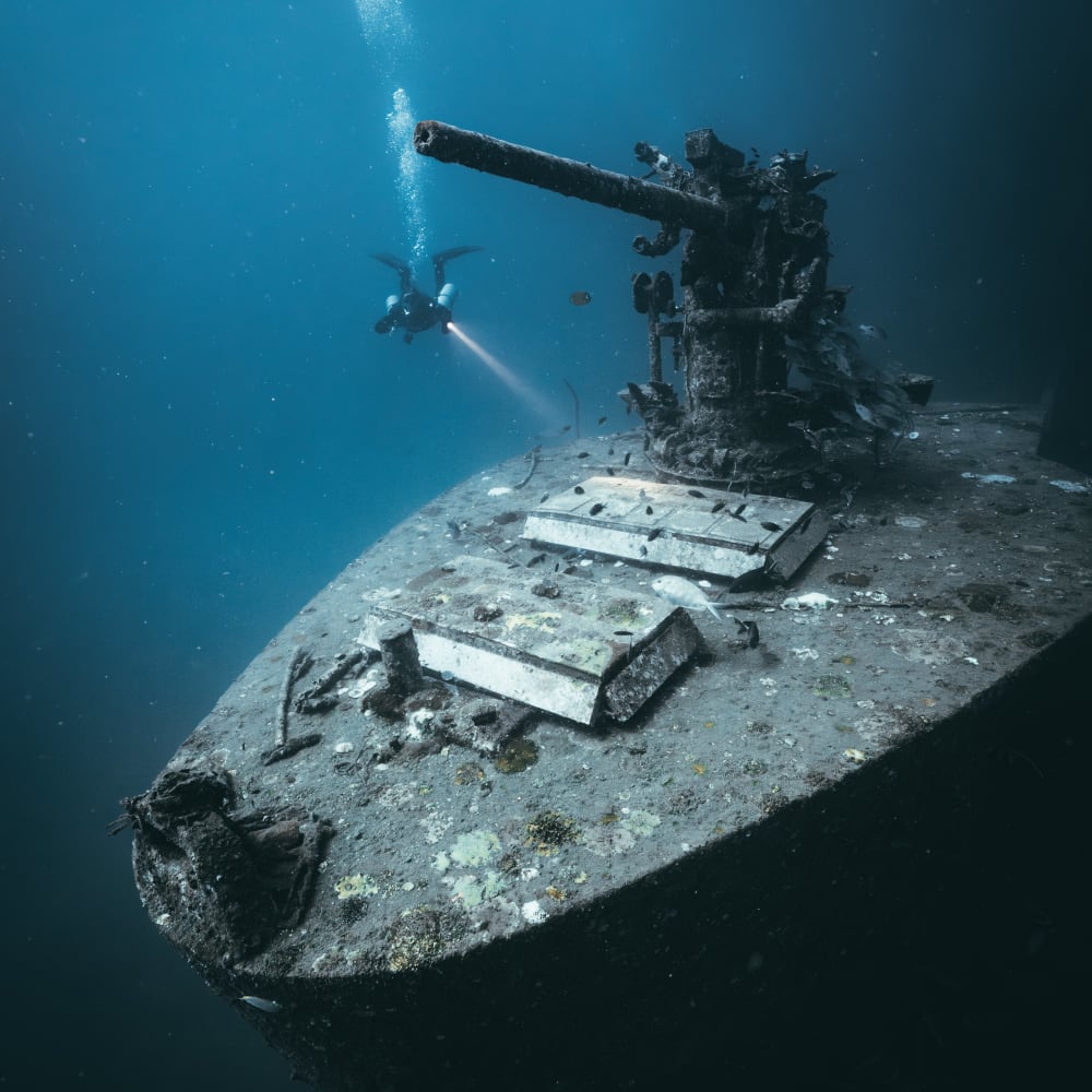 Koh Tao Divers diver approaching the upper deck of the HTMS Sattakut shipwreck in low visibility