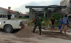 Aksi Sosial Babinsa Bersama Warga Gotong Royong Timbun Jalan Berlubang