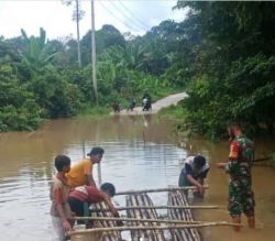 Babinsa Koramil 1013-01/Kandui Bantu Warga Menyebrangi Luapan Air.
