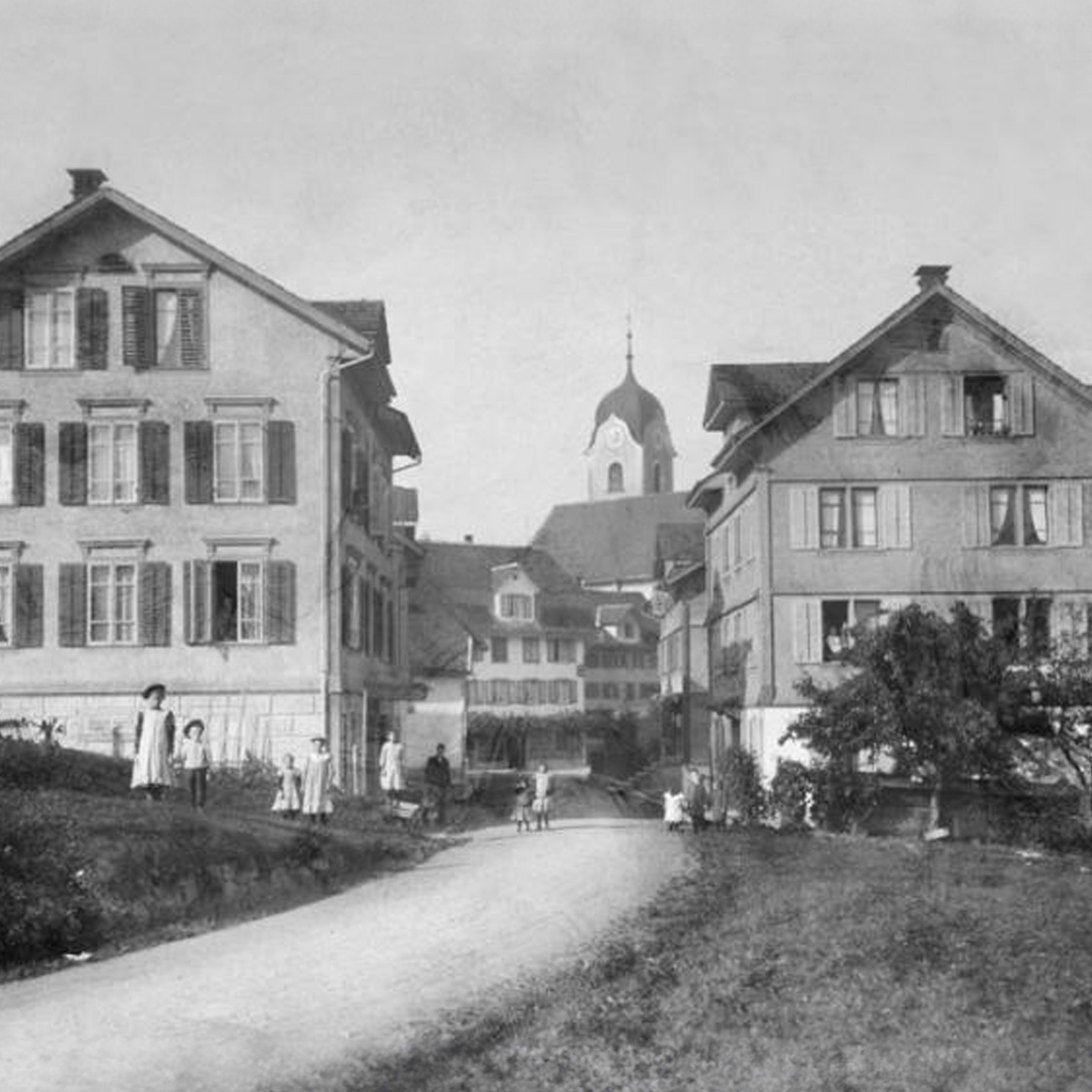 Restauriertes Foto von Wollerau um das Jahr 1900, das den Dorfkern mit Kirche zeigt.