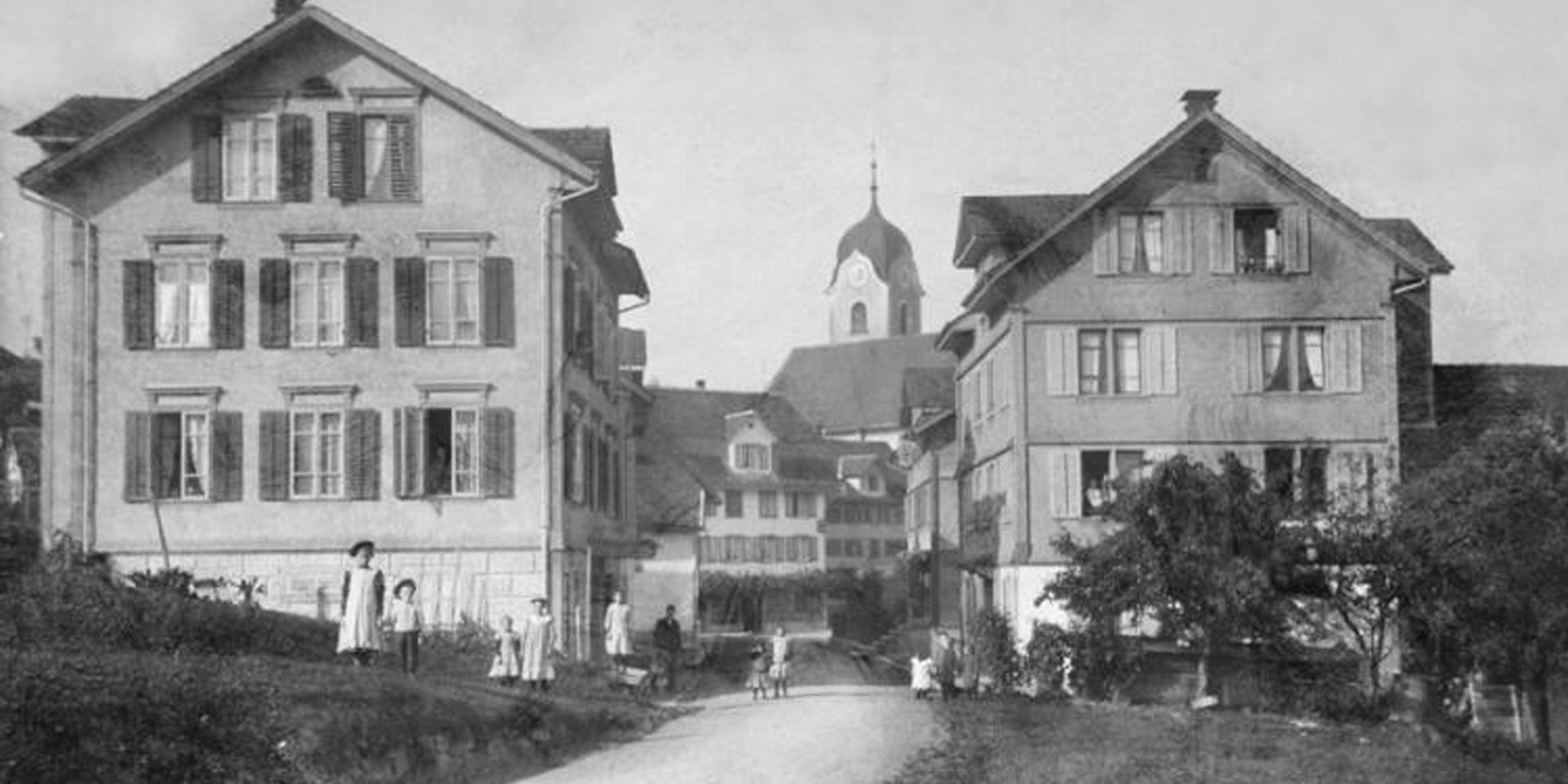 Restauriertes Foto von Wollerau um das Jahr 1900, das den Dorfkern mit Kirche zeigt.