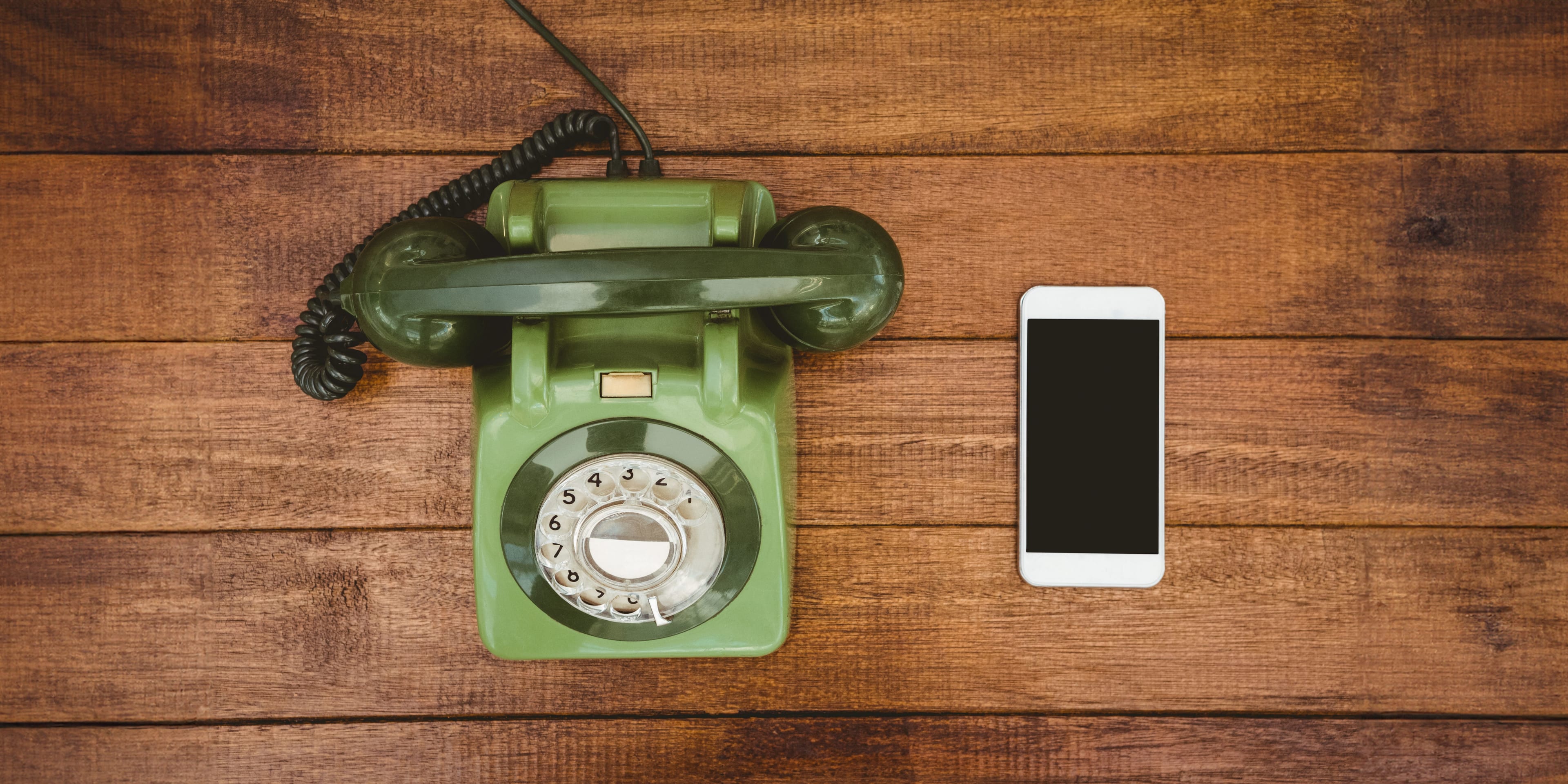 Stimmungsbild mit einem alten Telefon mit Drehscheibe und einem modernen Smartphone