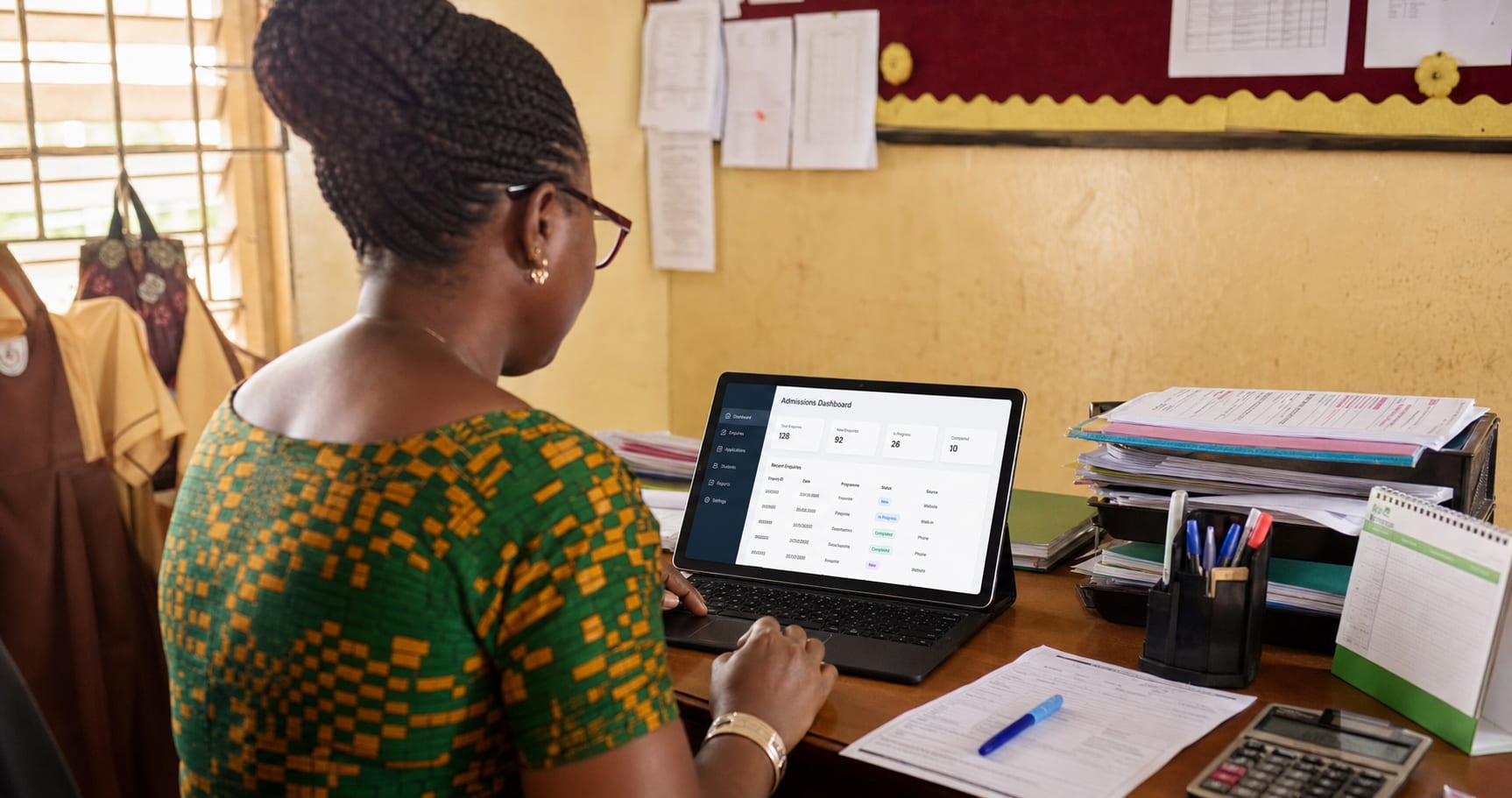 School administrator reviewing an admissions dashboard in a school office