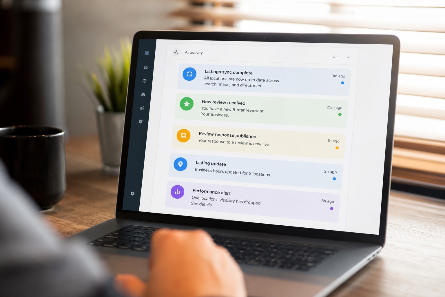 Laptop showing an activity feed for listing syncs, reviews, and local search alerts