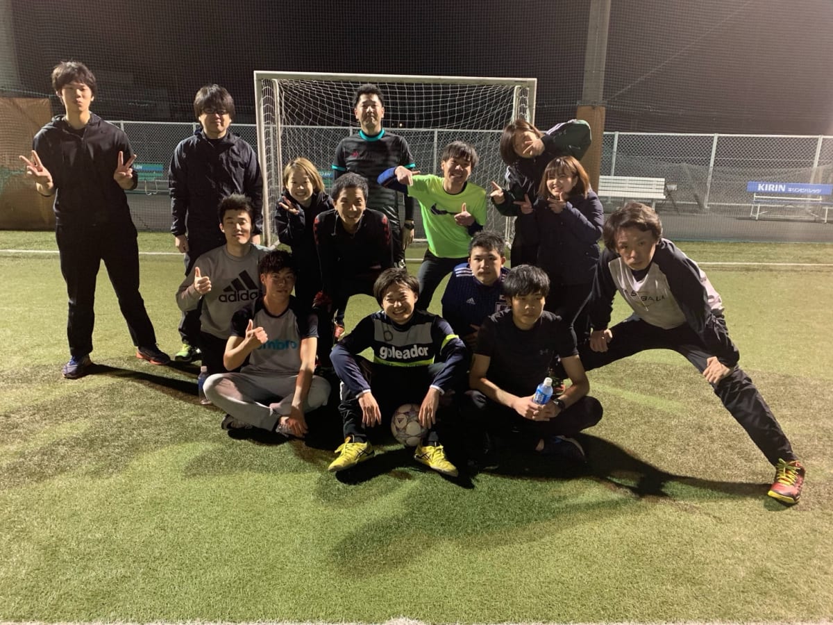 栃木でフットサルを楽しんだ仲間たちが、夜のフットサルコートでゴール前に集まっている集合写真
