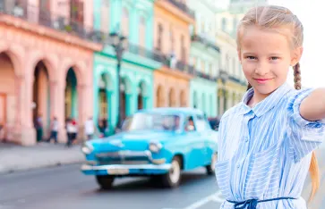 Adorable little girl taking selfie in popular area in Old Havana, Cuba. Portrait of kid outdoors on a street of Havana