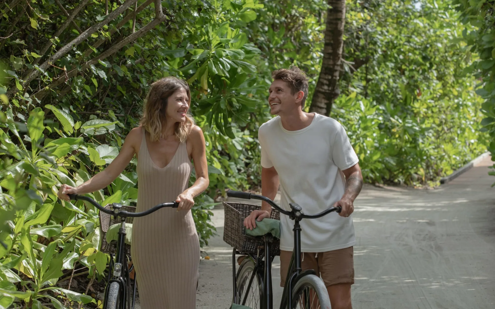 Six Senses Laamu in Laamu-Atoll:  Guests walking with bicycles jungle path