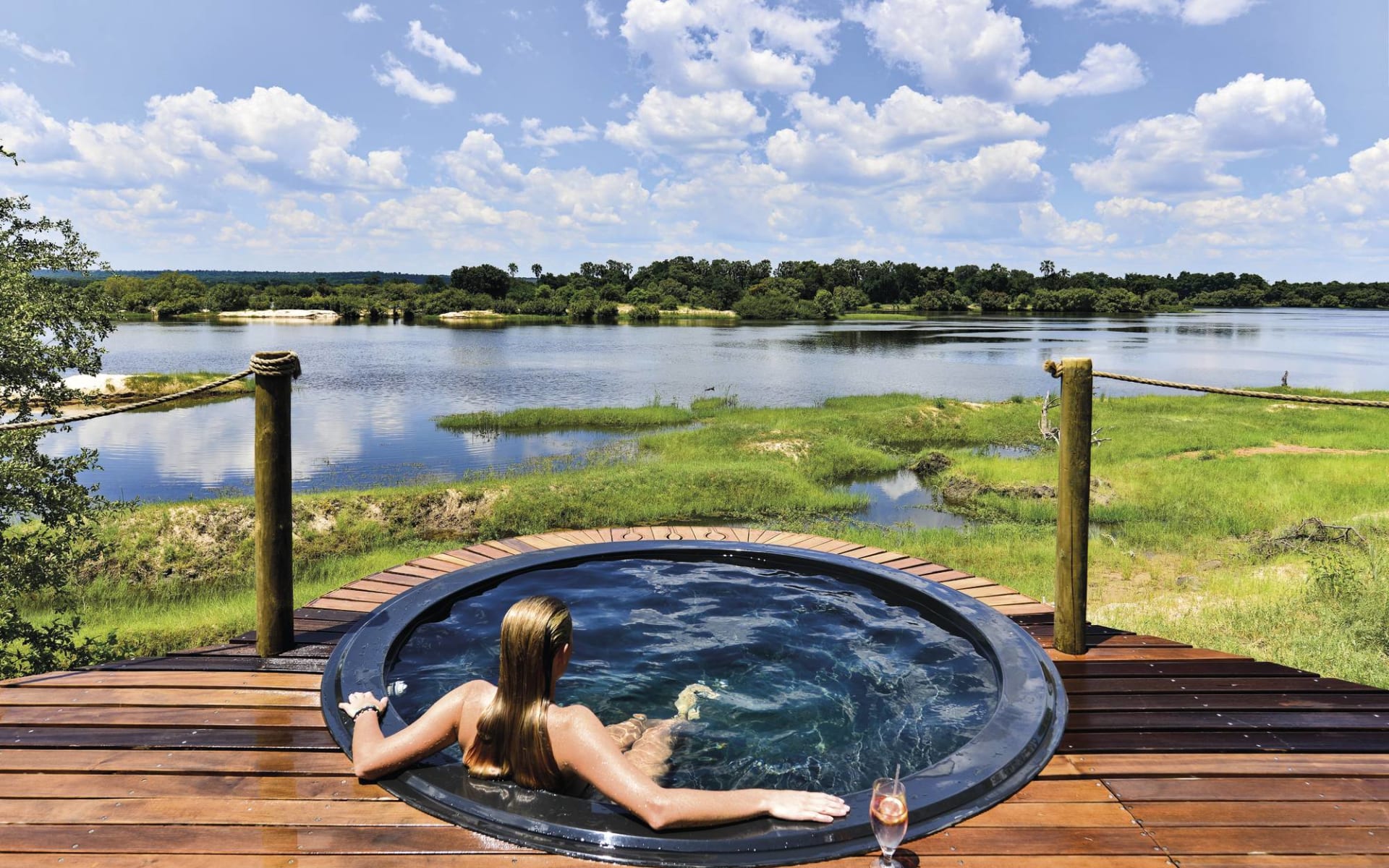 Victoria Falls River Lodge:  Victoria Falls River Lodge - Planschpool mit Frau und Blick auf Zambezi