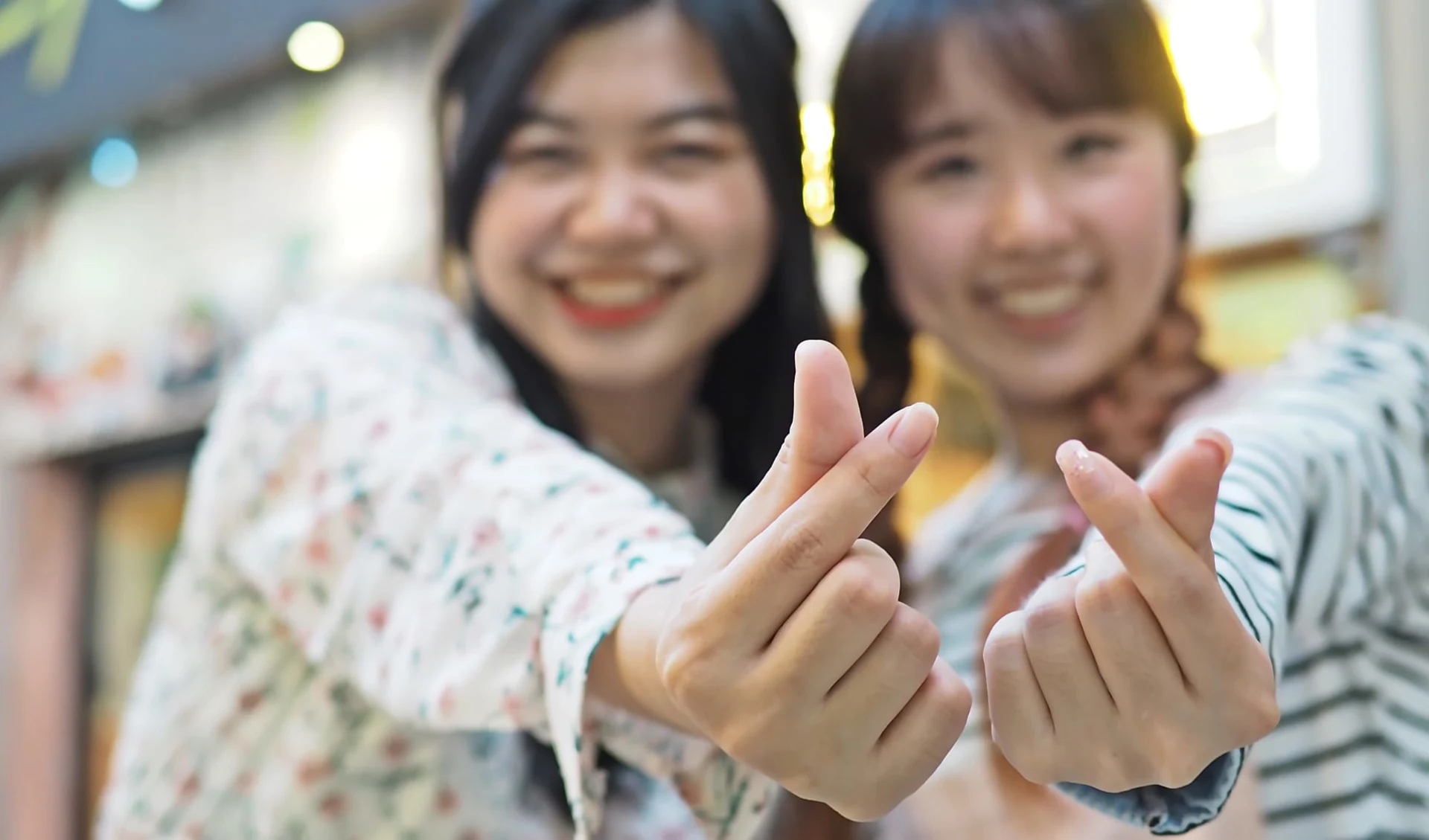 Südkoreas unbekannter Westen ab Seoul: Asian girls making mini heart shaped finger hand gesture (Korean style)