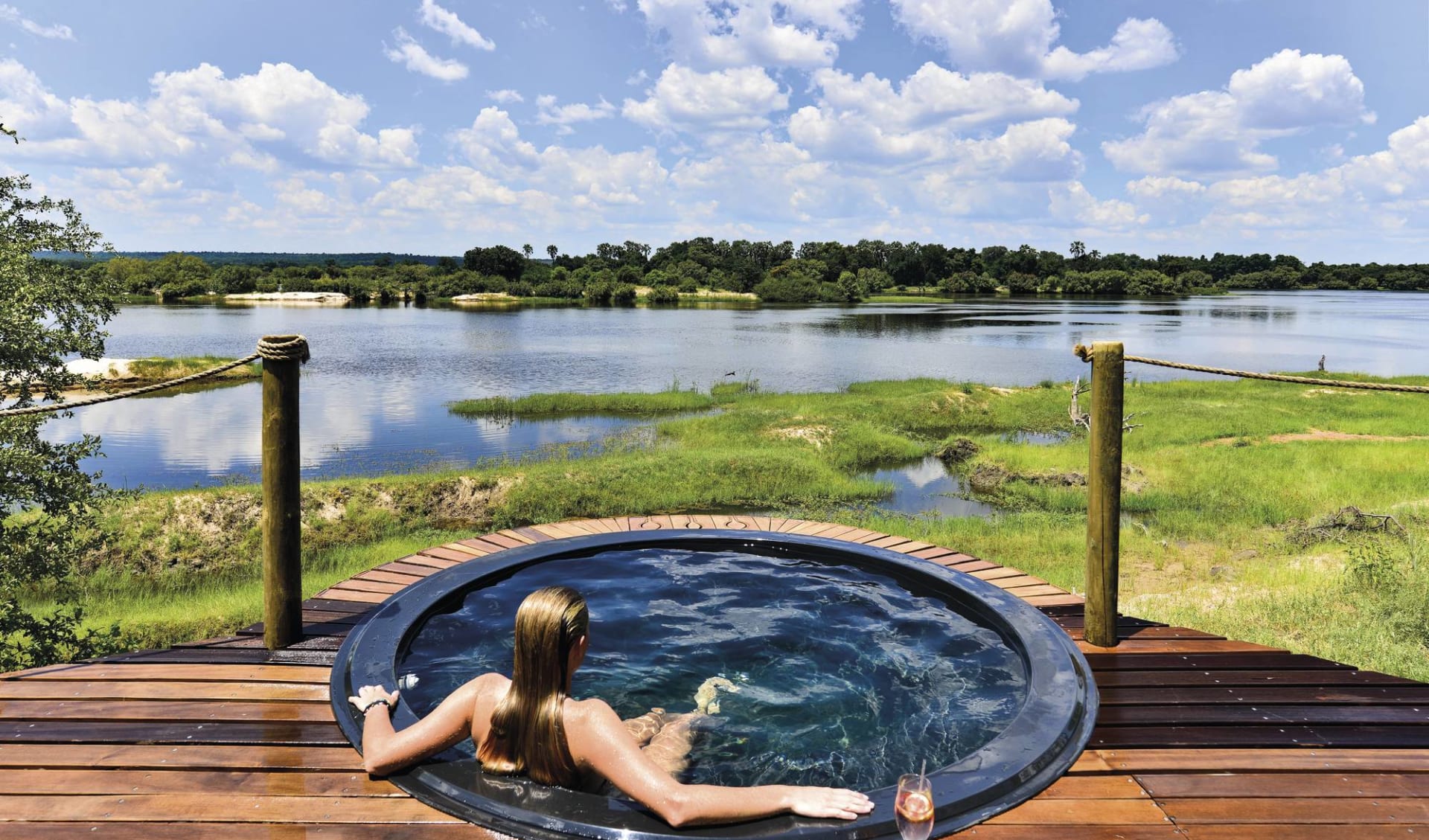 Victoria Falls River Lodge:  Victoria Falls River Lodge - Planschpool mit Frau und Blick auf Zambezi