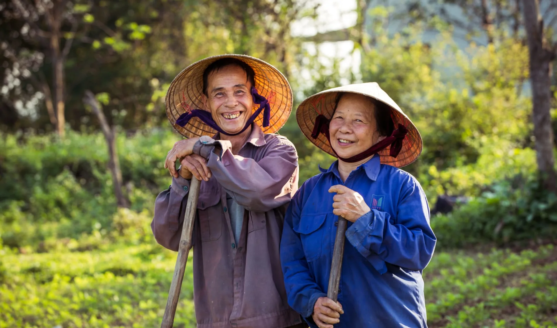 Zentralvietnam aktiv erleben ab Hue: Smiling old farmer couple with conical hats (non la)