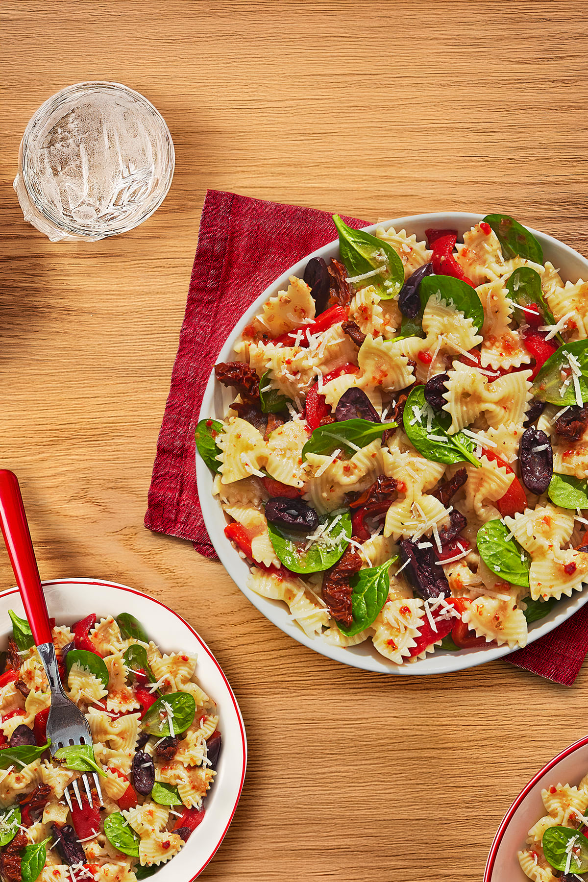 Bow tie pasta is tossed with spinach, sundried tomatoes, olives, and red bell peppers. 