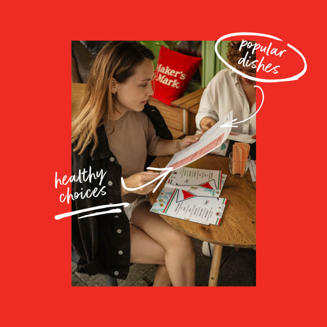 Woman sitting at a table looking at a menu