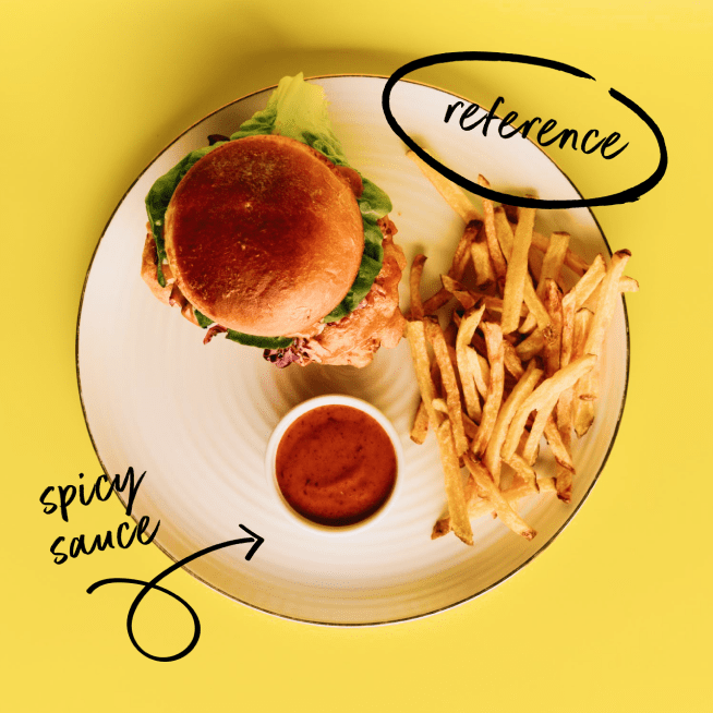 Burger, fries and spicy sauce on a plate in front of yellow background