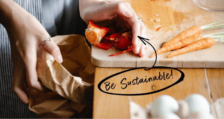 Woman putting vegetable cuttings from cutting board into a brown paper bag