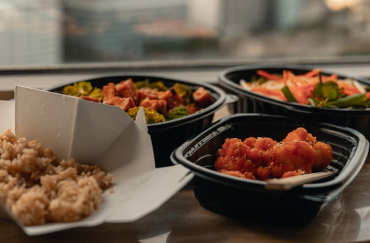 Food in takeout containers on a wooden table