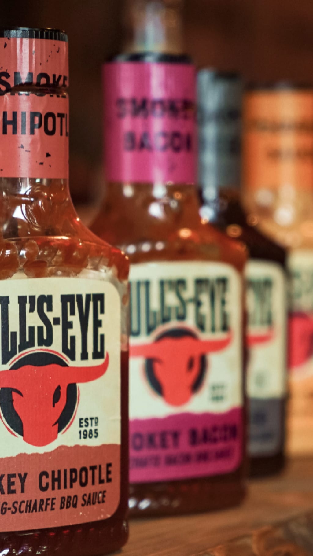 A collection of Bull's-Eye sauces on a wooden counter.