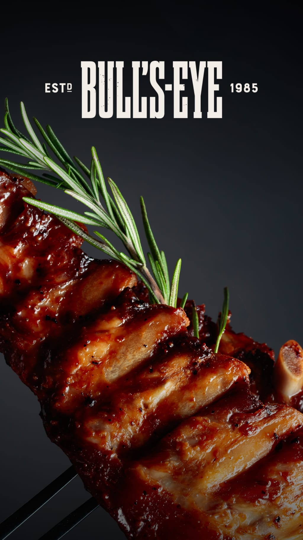 A rack of ribs on a BBQ fork, slathered in BBQ sauce and garnished with rosemary.