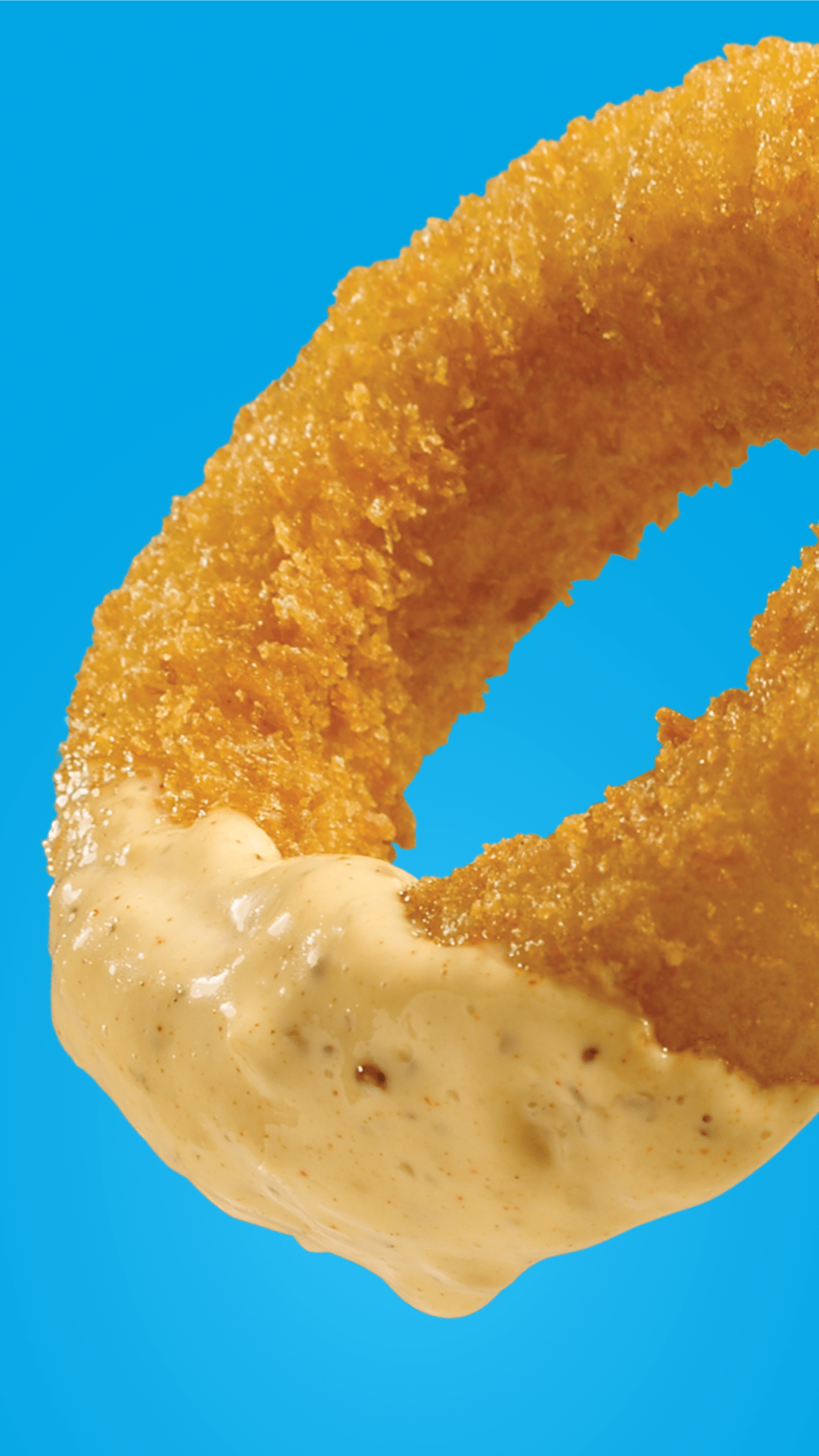 An onion ring dipped in Miracle Whip