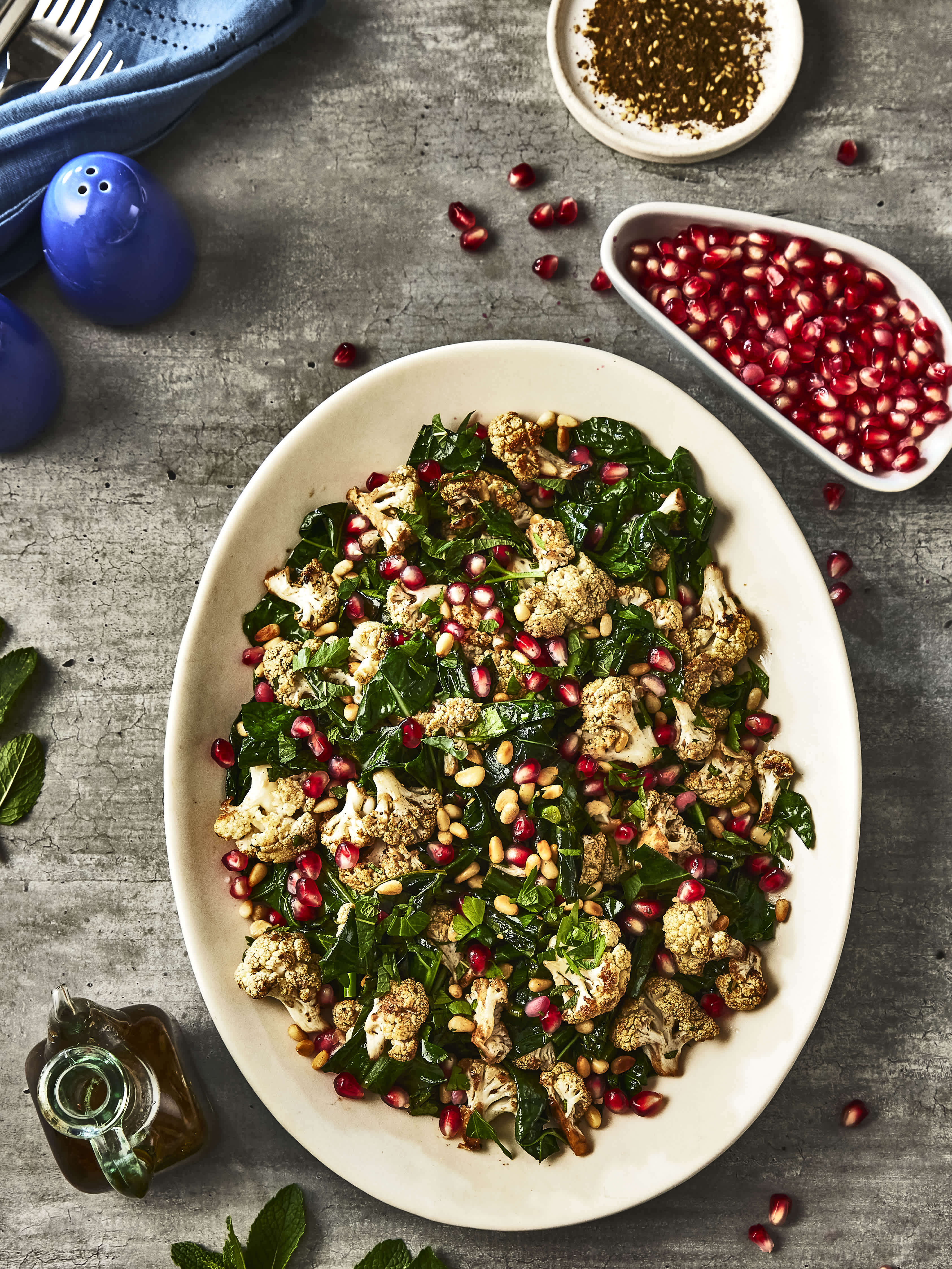 A big bowl of delicious Zaatar-Roasted Cauliflower and Pomegranate salad topped with Pure by J.L. Kraft Dressings.