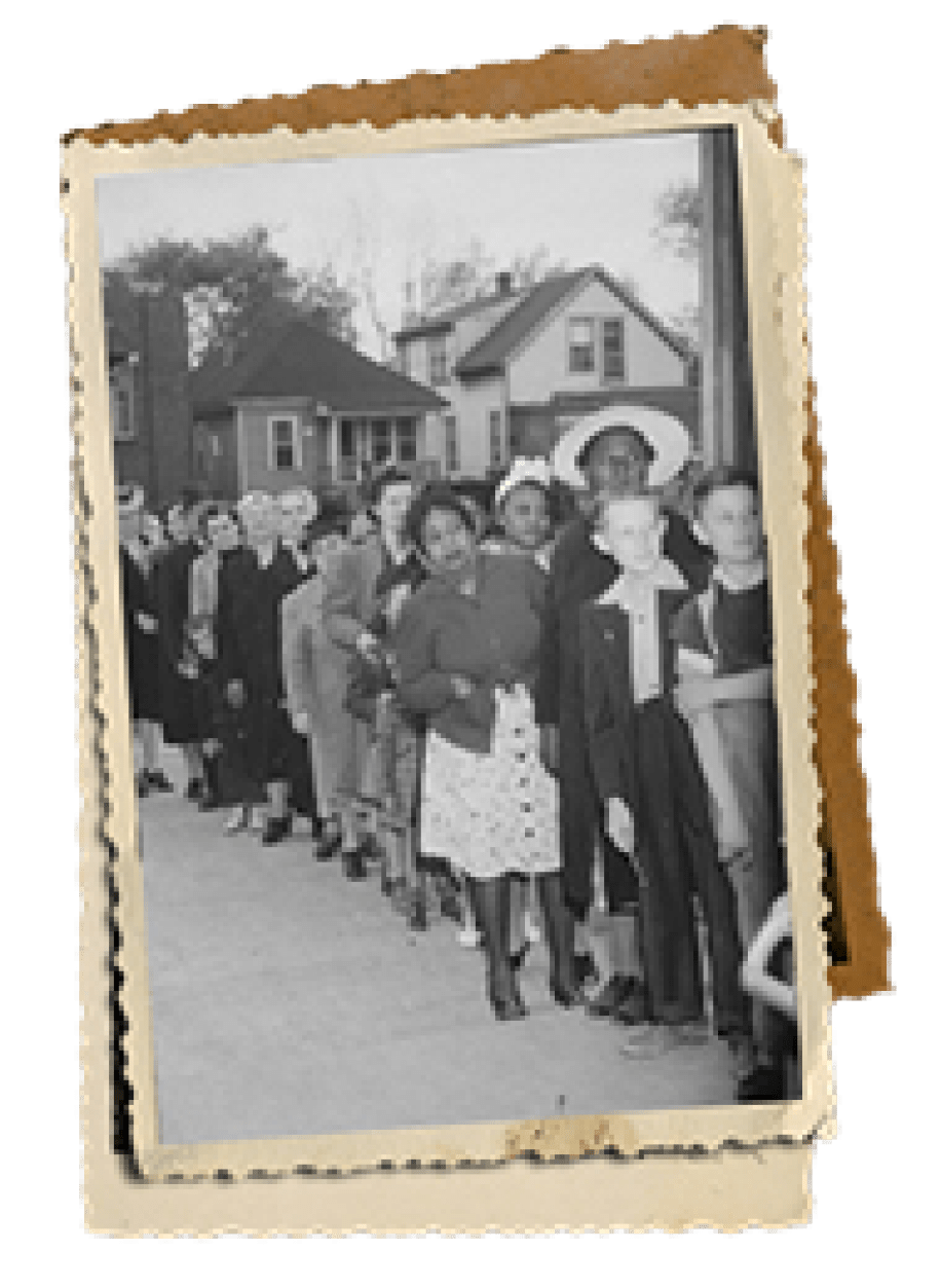 Une photo historique de personnes faisant la queue dehors.