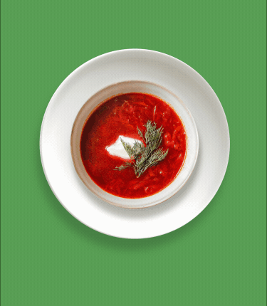 Red soup in a bowl with garnish