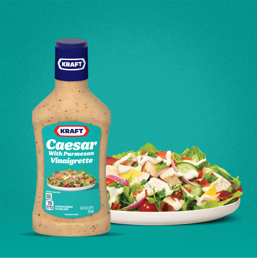 Kraft Caesar With Parmesan Vinaigrette bottle beside a fresh salad, highlighting its savory for enhanced meals.