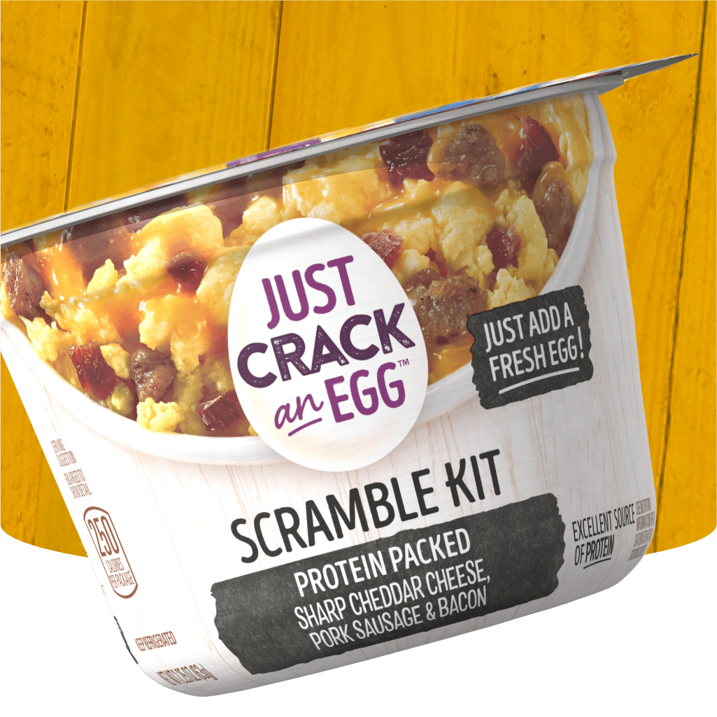 A package of Just Crack an Egg Scramble Kit, highlighting the protein-packed ingredients of sharp cheddar cheese, pork sausag