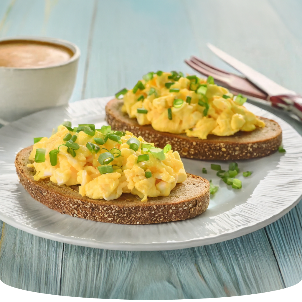 Scrambled eggs on toast with chives and a cup of coffee.