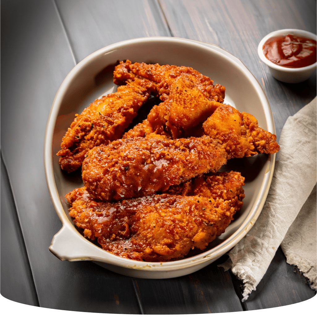 Fried chicken tenders in a bowl with ketchup.