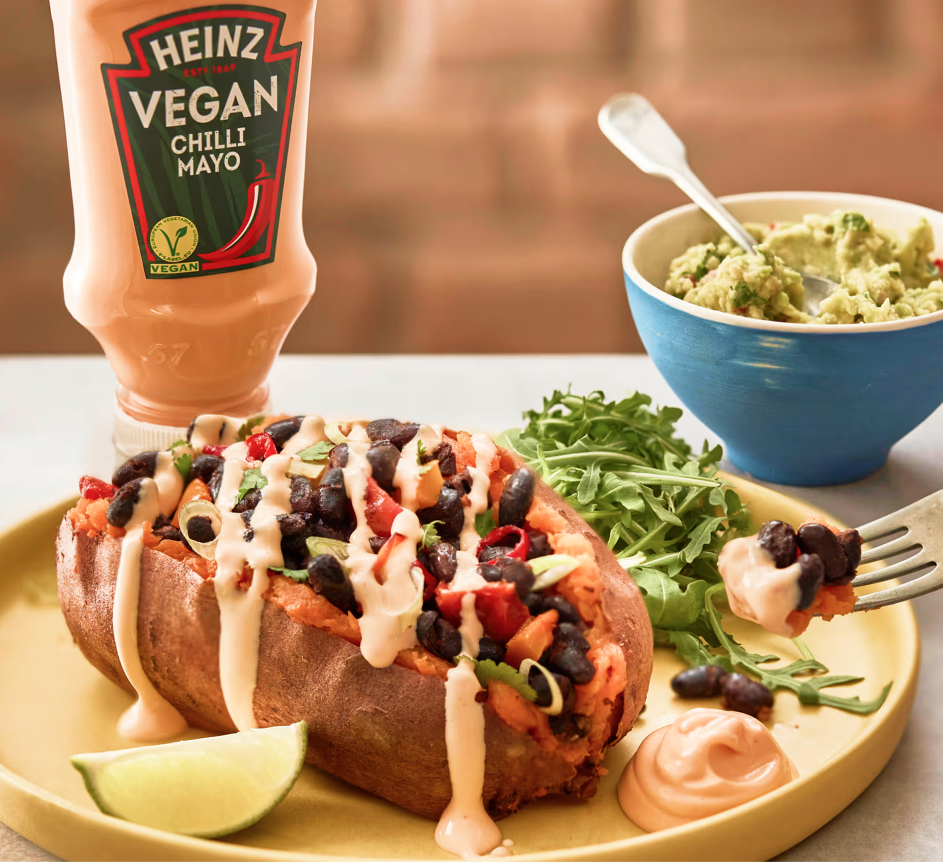 Deliciosa papa rellena con frijoles negros, pimientos y mayonesa de ají vegana Heinz.