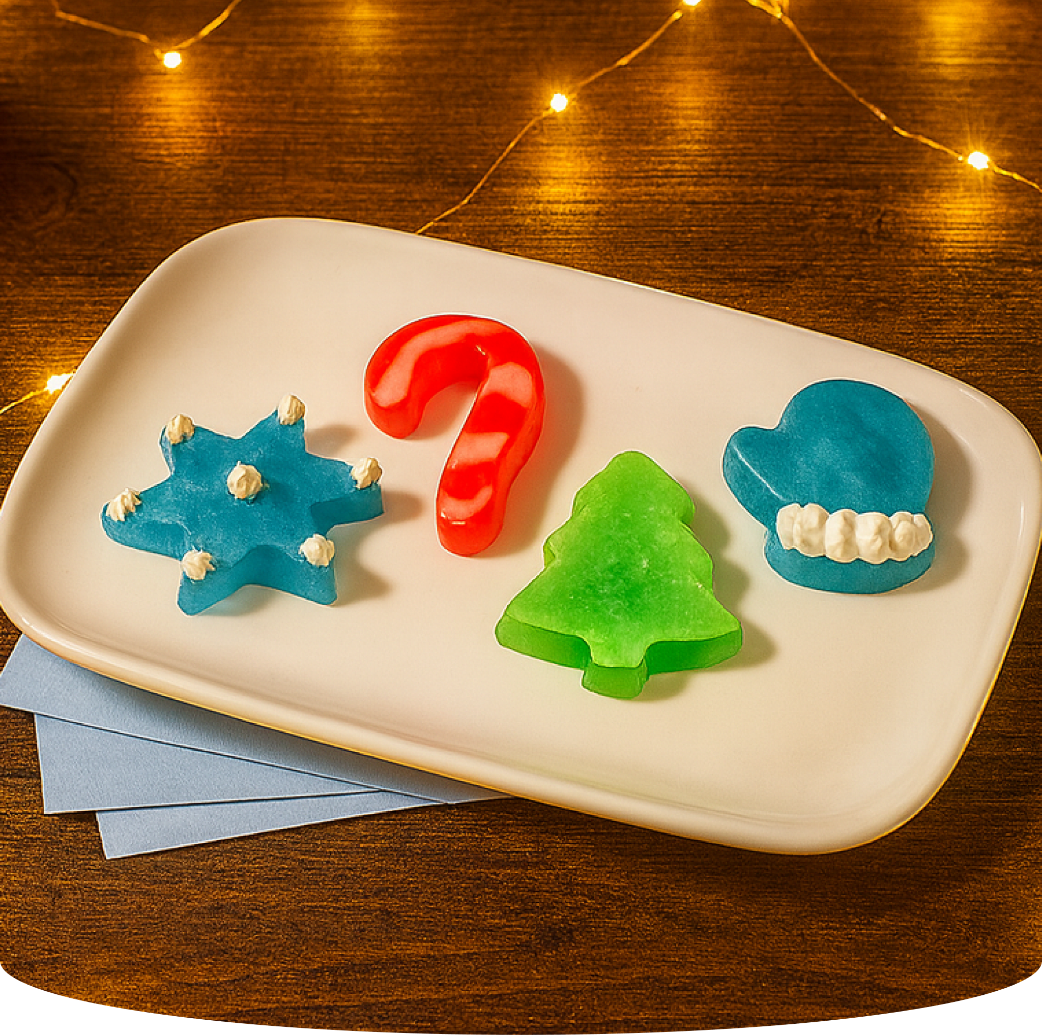 Christmas-themed candies on a plate with string lights in the background.