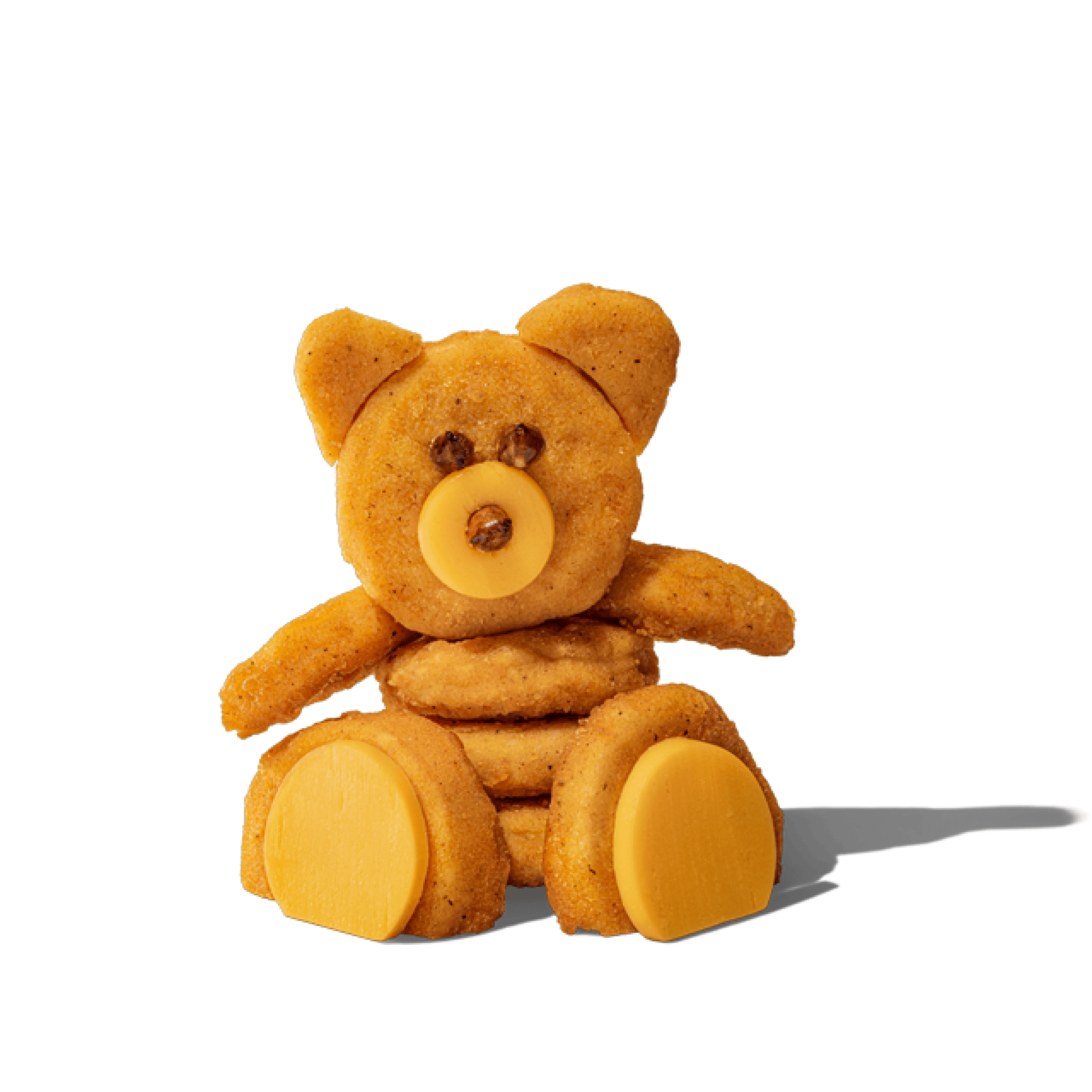 A teddy bear made of stacked donut-shaped fried foods with cheese accents, set against a black backdrop.