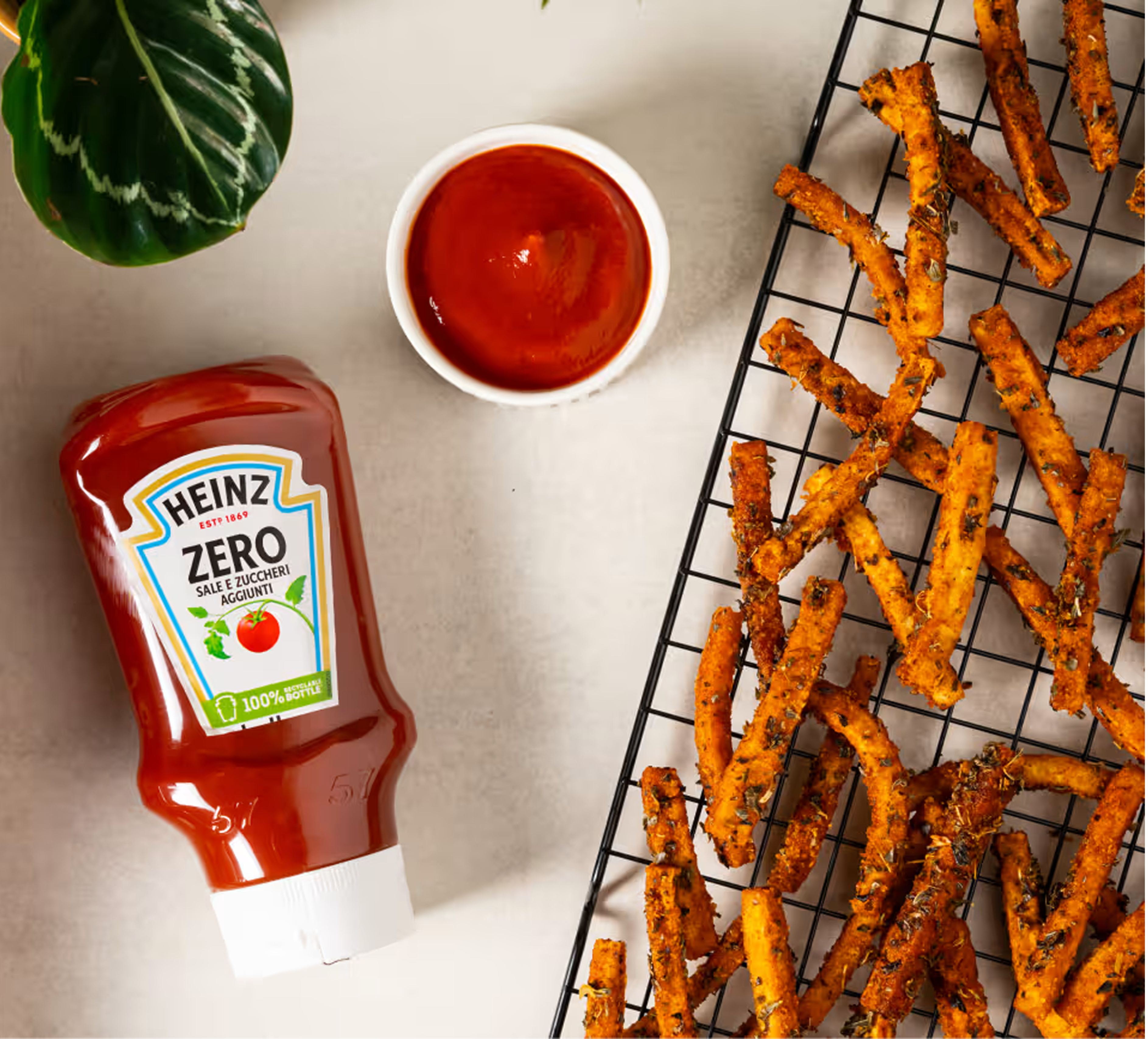 Una vista dall'alto di patatine di zucca al forno croccanti e speziate, disposte su una griglia metallica. Le patatine sono d