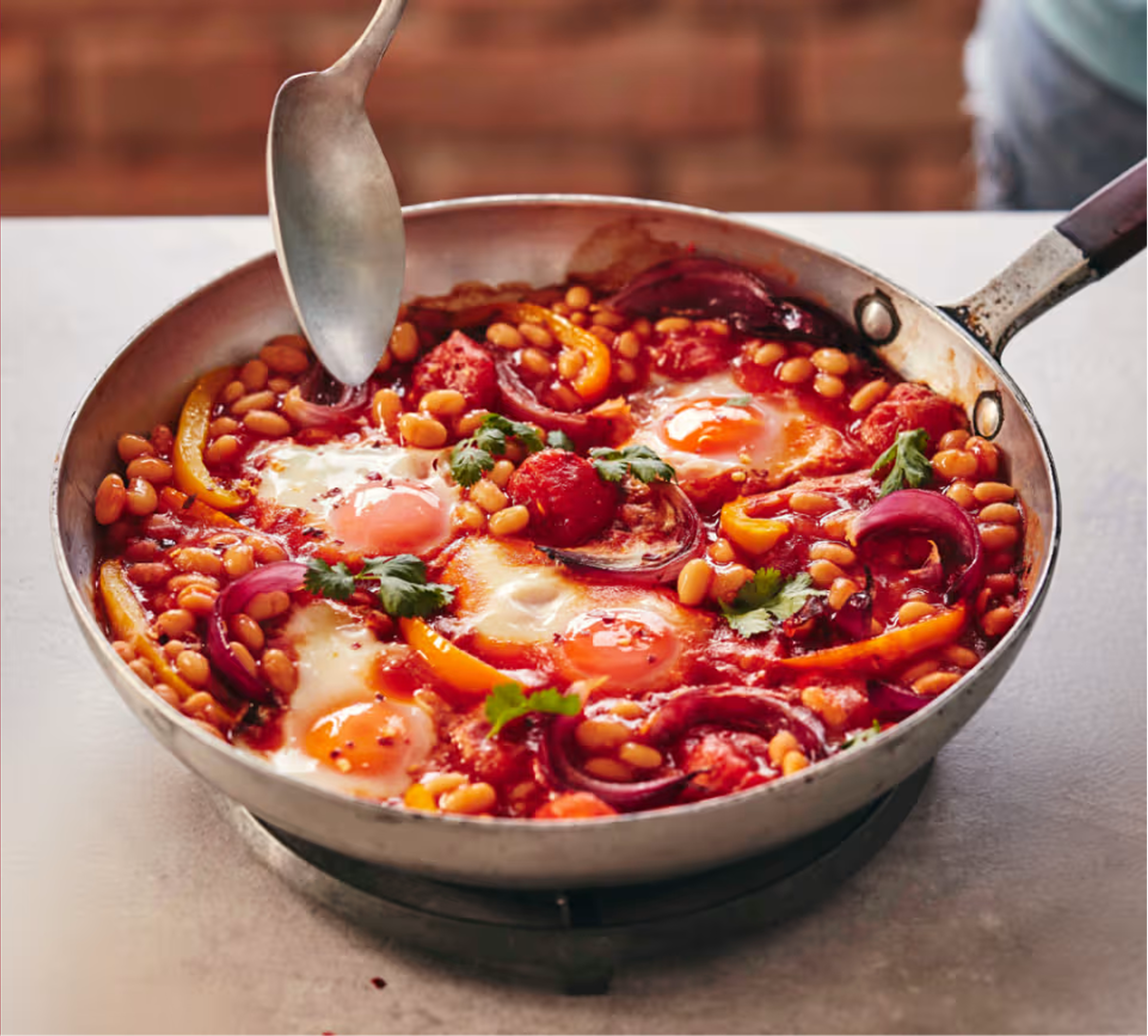 Jajka po wiejsku inspirowane przepisem na pikantną kiełbaskę chorizo, jarmuż i fasolkę Beanz. Zbliżenie na patelnię z jajkami