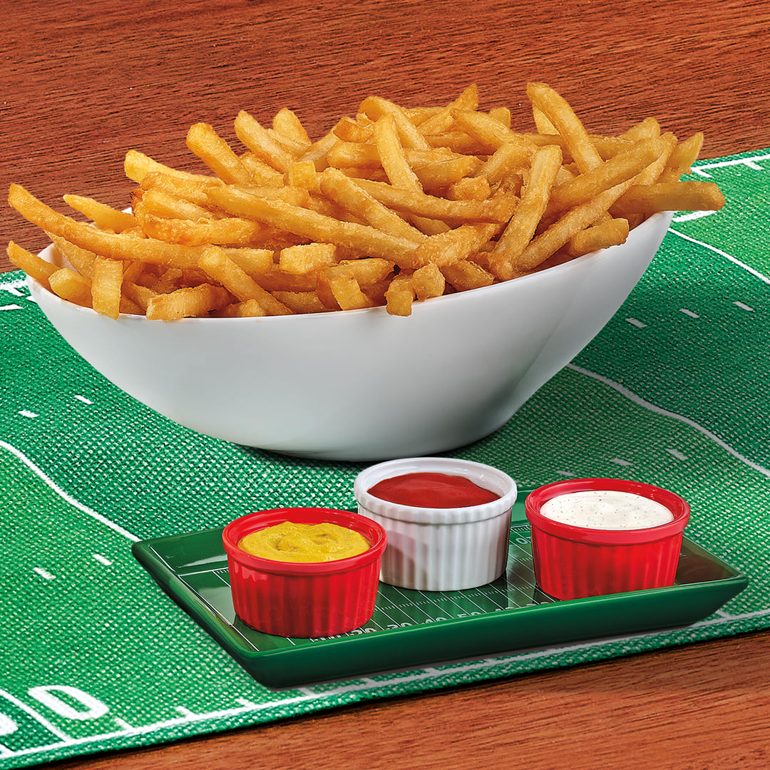 A bowl of crispy fries with a condiment flight of mustard, ketchup, and ranch for the win.