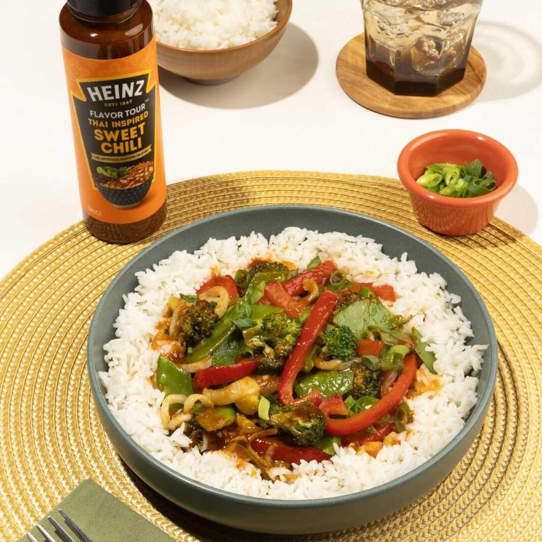 A vibrant overhead image of a stir-fry dish featuring colorful vegetables like broccoli, red peppers, and snow peas served ov