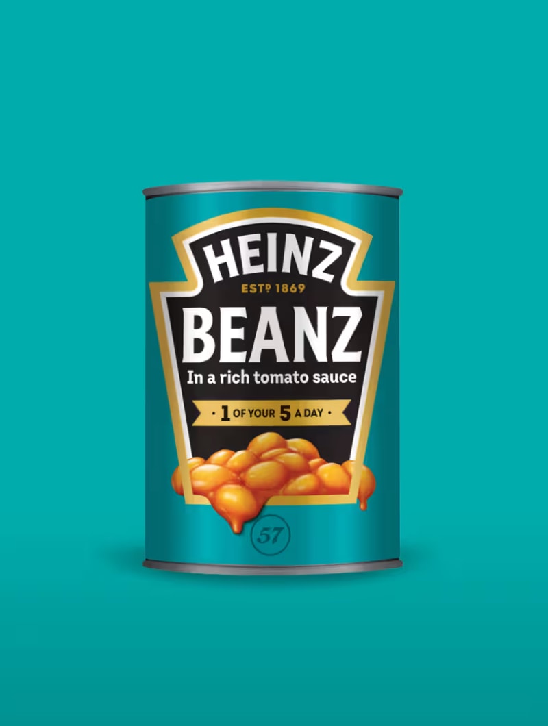 Egy Heinz Beanz babkonzerv, címkéjén babbal, türkizkék háttér előtt.