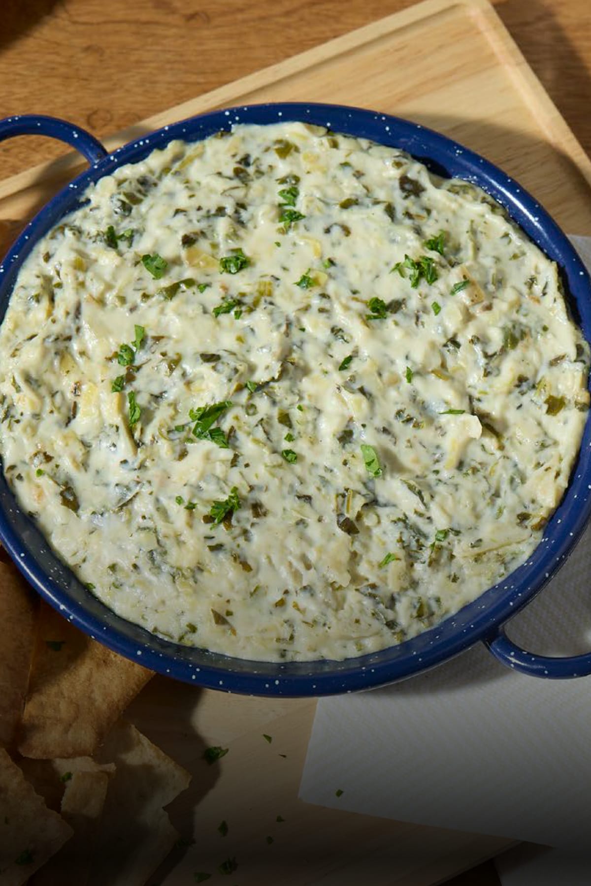Creamy spinach artichoke dip made with Philadelphia cream cheese in a blue serving dish.