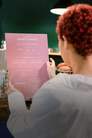 A person reviewing a menu from Rosie's Coffee.