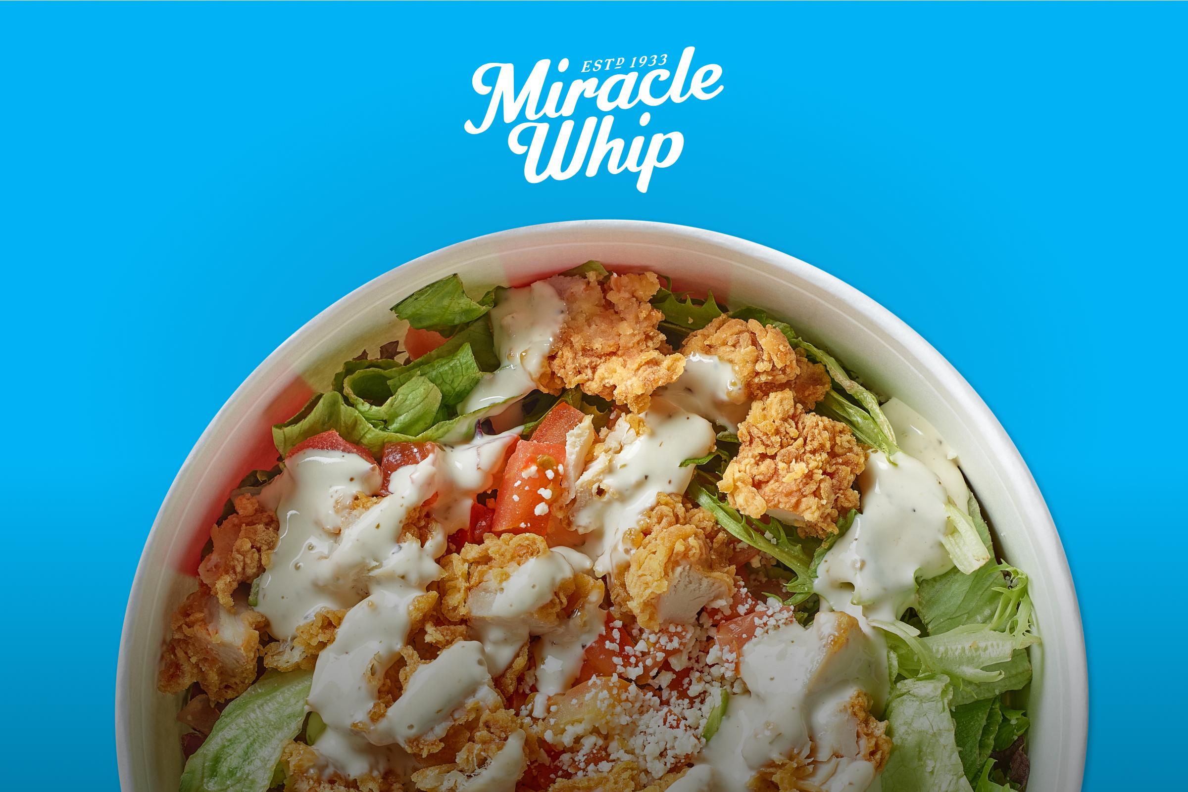 Salad with fried chicken and Miracle Whip dressing on a bright blue background.