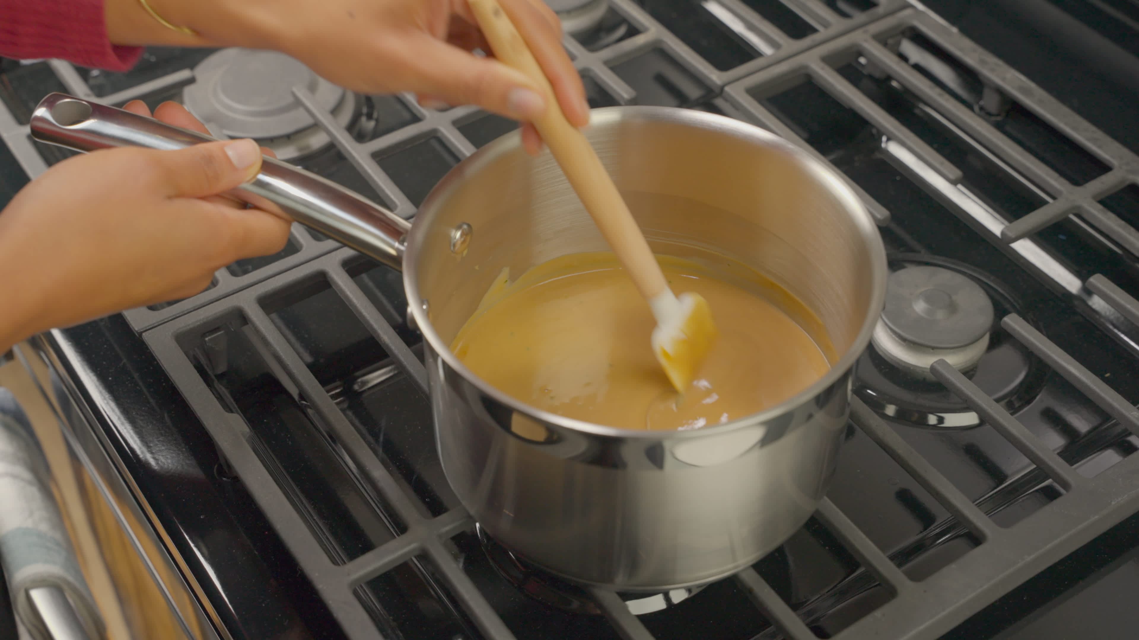Beef gravy and onion dip being mixed and cooked in a medium saucepan on medium heat for 3 to 4 minutes.
