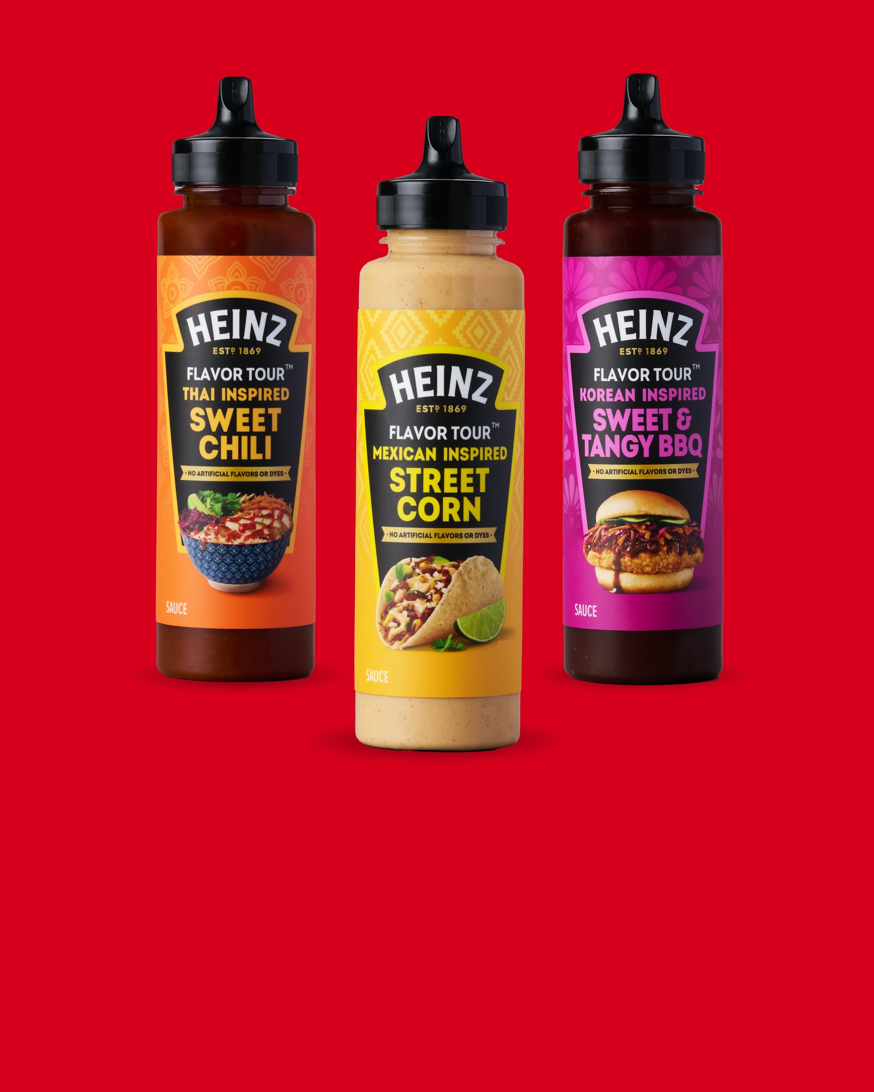 Three bottles of Heinz Flavor Tour sauces stand against a vibrant red backdrop. From left to right, they are: Korean Inspired