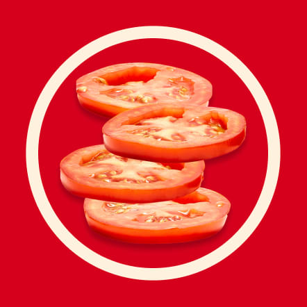 Four thin slices of ripe red tomato are displayed on a vibrant red background, arranged in a slightly overlapping, staggered stack within a contrasting off-white circle. The juicy interior and seeds of the tomatoes are clearly visible. This image represents four servings.