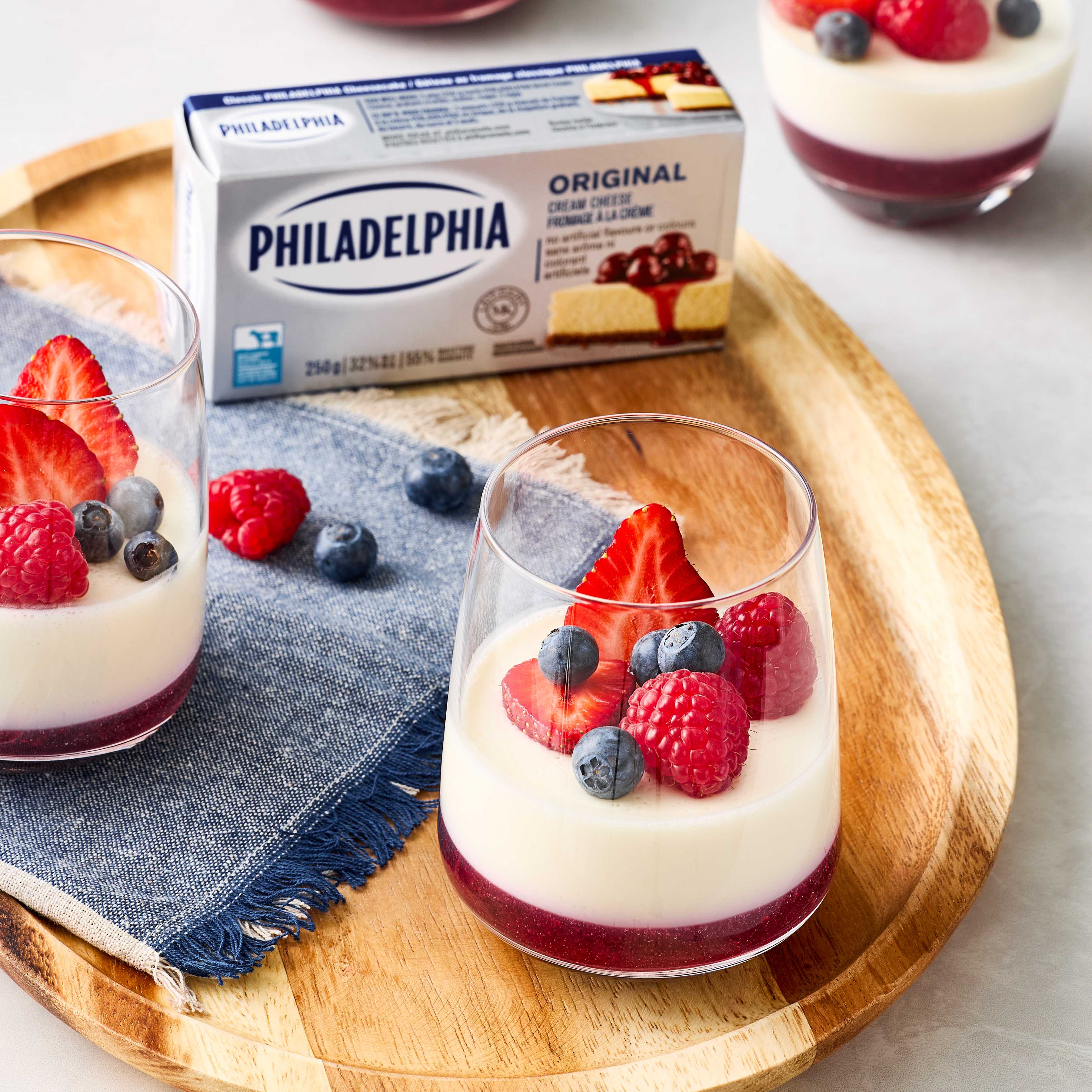 Creamy raspberry panna cotta topped with Philadelphia cream cheese and fresh berries near Philadelphia packaging.