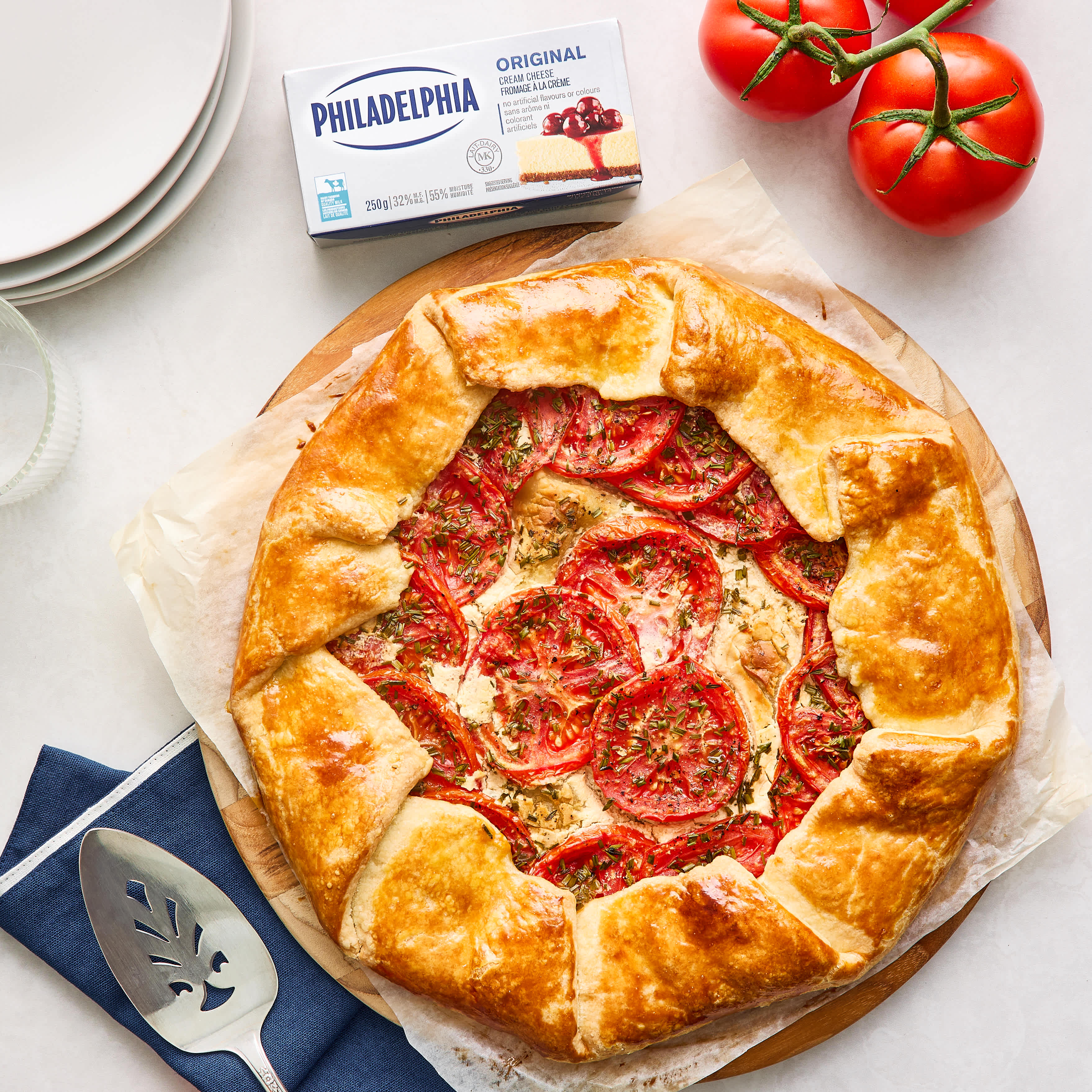 Rustic Tomato & Cream Cheese Tart next to a Philadelphia Cream Cheese box and fresh vine-ripened tomatoes.